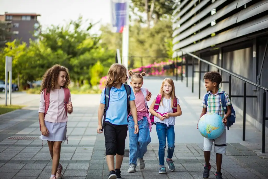 international vs language school — diverse group of young students walking outside international school abroad