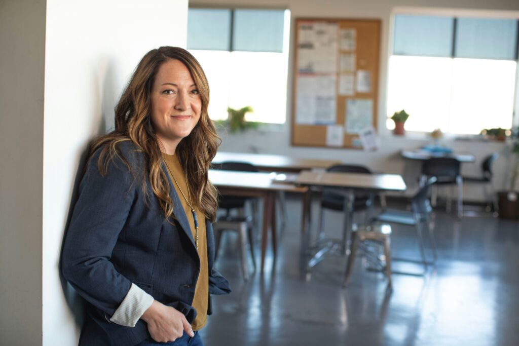 Female teacher standing confidently in a classroom considering teaching abroad FAQs before making her decision