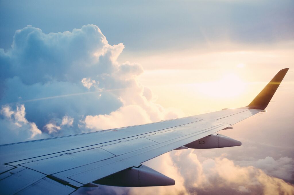 what to pack to teach abroad — airplane wing view at sunset on long haul flight