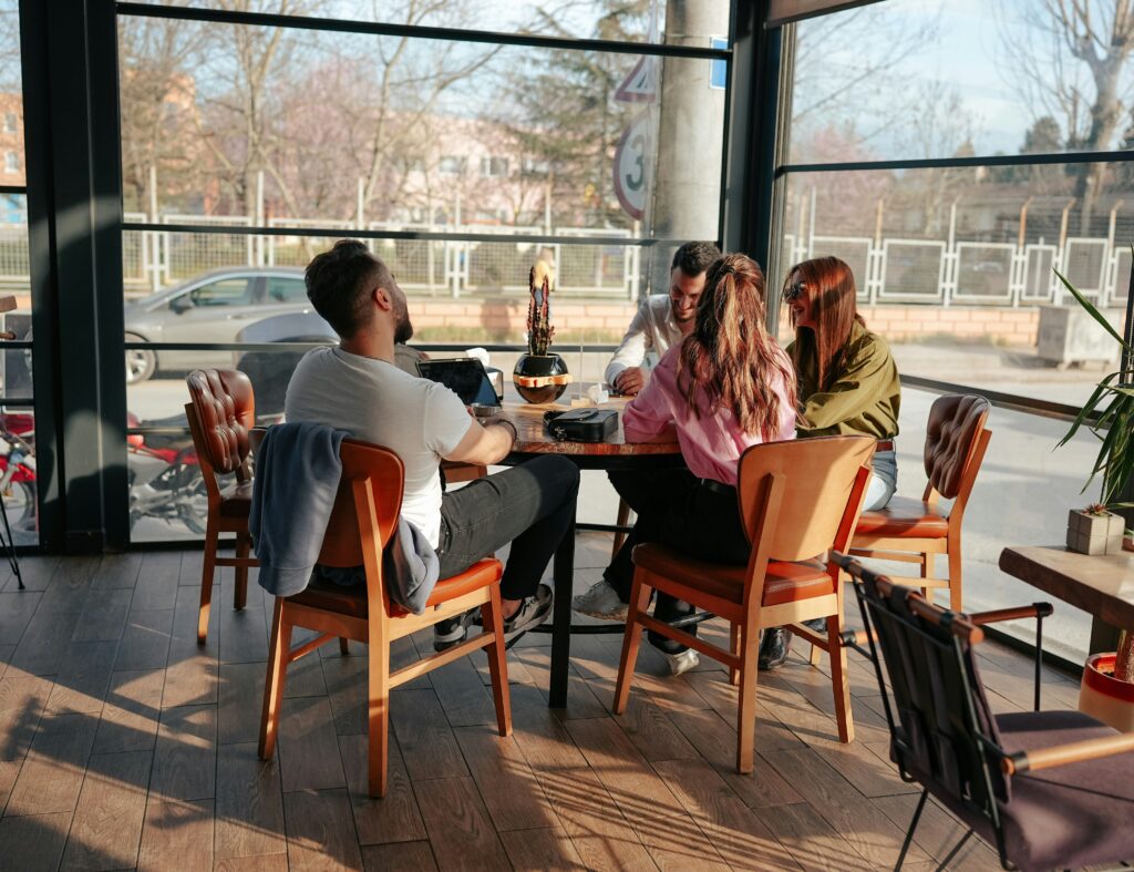 Group of TEFL course students studying together at a café table with laptops during an in person TEFL course abroad