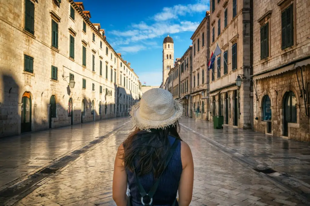 Woman walking through Dubrovnik's old town — first days abroad