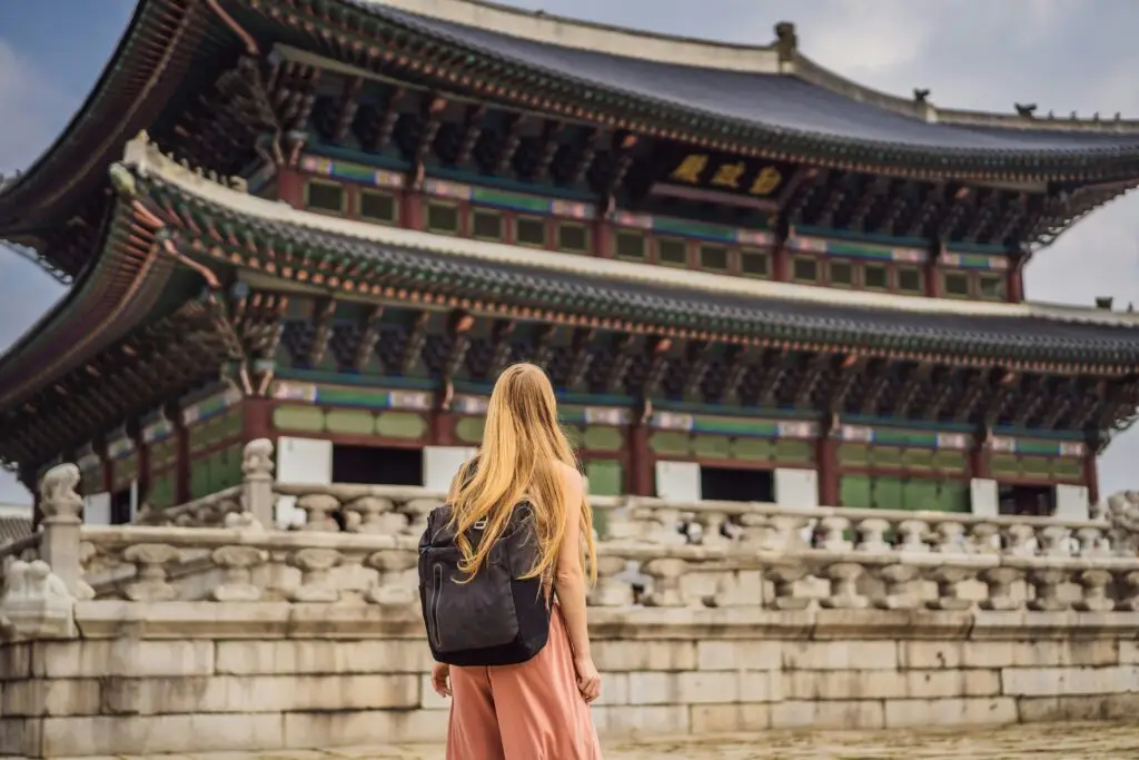 Woman with backpack looking at Gyeongbokgung Palace in Seoul, South Korea — teach English in South Korea EPIK