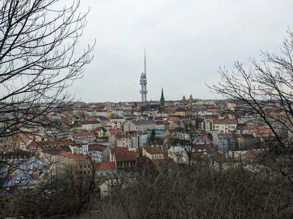 Aerial view of Žižkov's rooftops in Prague with the TV Tower rising above the neighborhood.