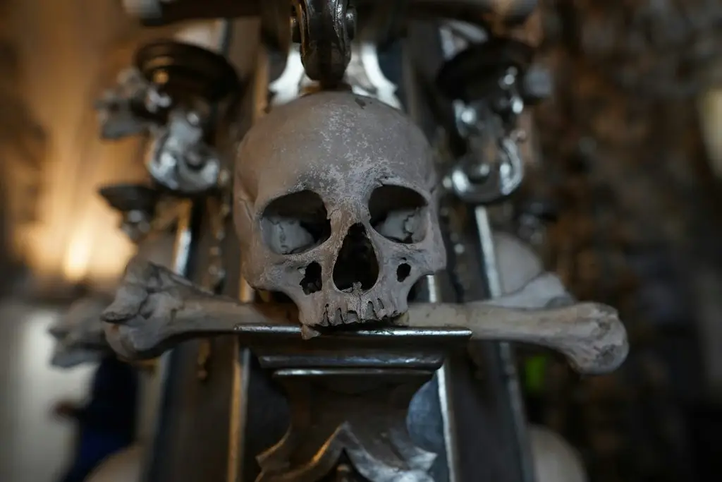A human skull and crossbones mounted in the Sedlec Ossuary (the Bone Church) in Kutná Hora, decorated with the remains of roughly 40,000 people.