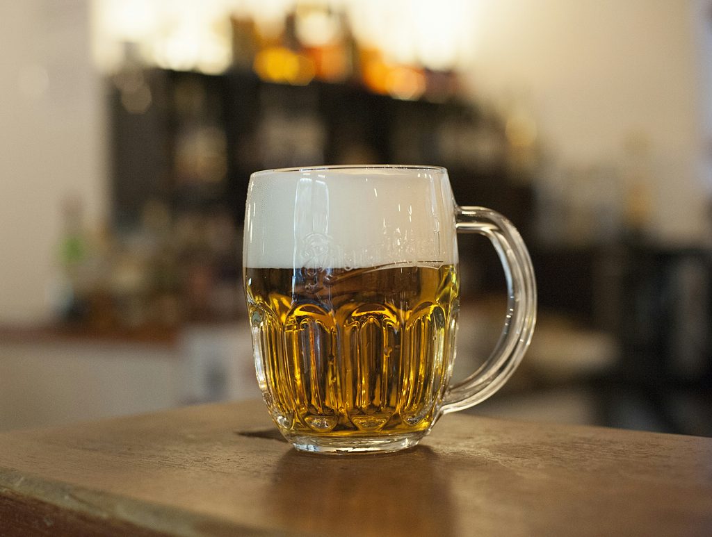 A Czech-style beer mug with a proper hladinka pour — two-thirds golden lager, one-third thick foam.