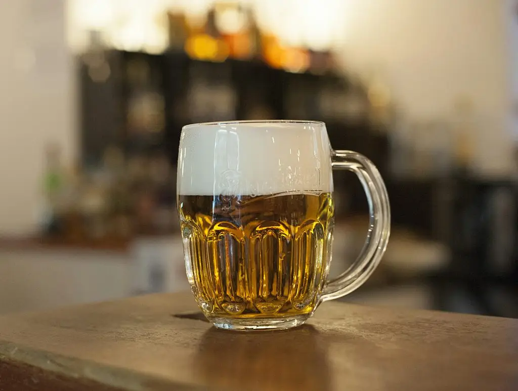 A Czech-style beer mug with a proper hladinka pour — two-thirds golden lager, one-third thick foam.