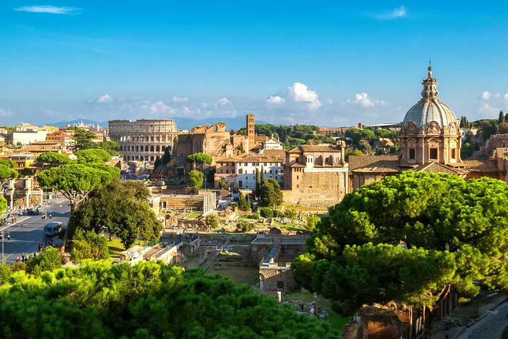 Spring break in Rome: the Colosseum and Roman Forum ruins seen from above, with umbrella pines in the foreground.